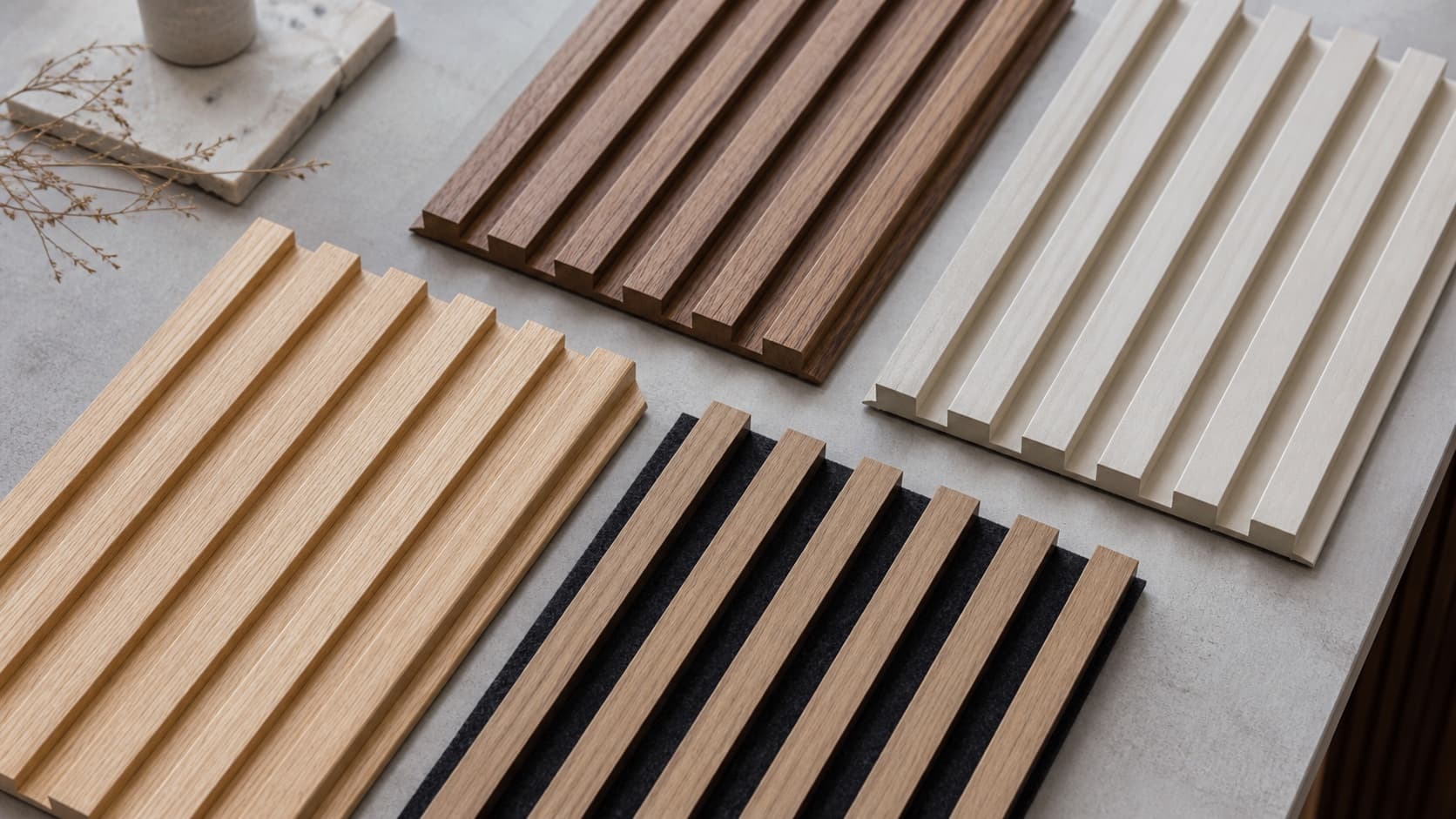 Four fluted wall panel material samples arranged in an interior design studio